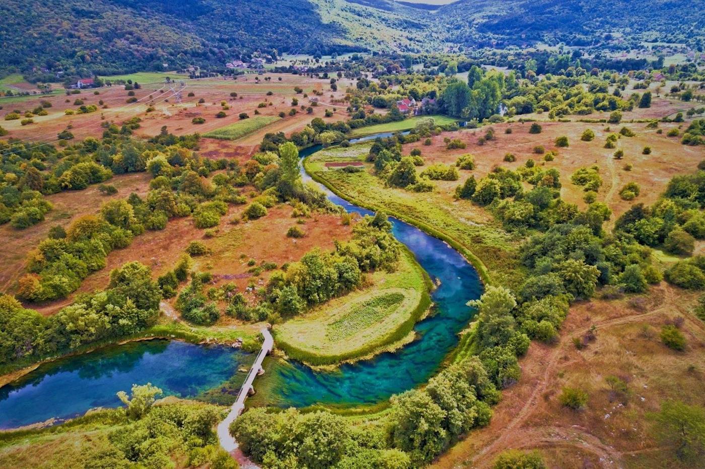 Kristalno čista rijeka Gacka vijuga ličkim krajolikom / A crystal-clear Lika river winding through the landscape